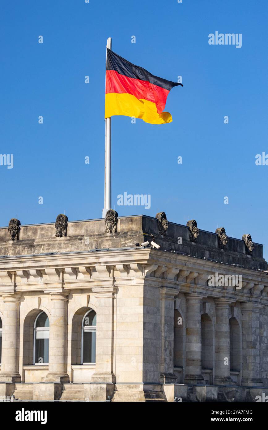 The National Flag of Germany flies on top of the Reichstag Building and Bundestag Parliament, Berlin, Germany Stock Photo