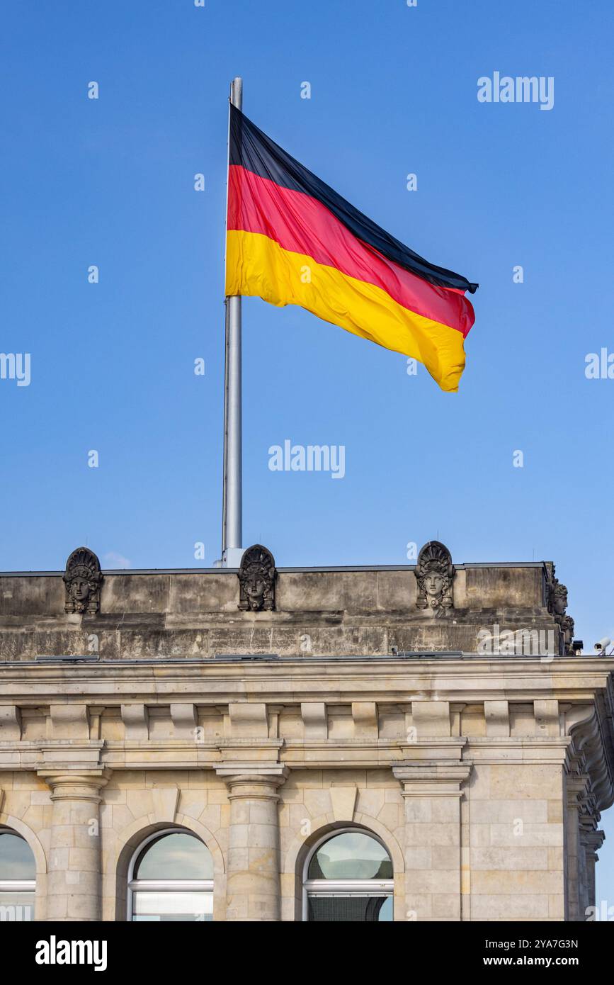 The National Flag of Germany flies on top of the Reichstag Building and Bundestag Parliament, Berlin, Germany Stock Photo