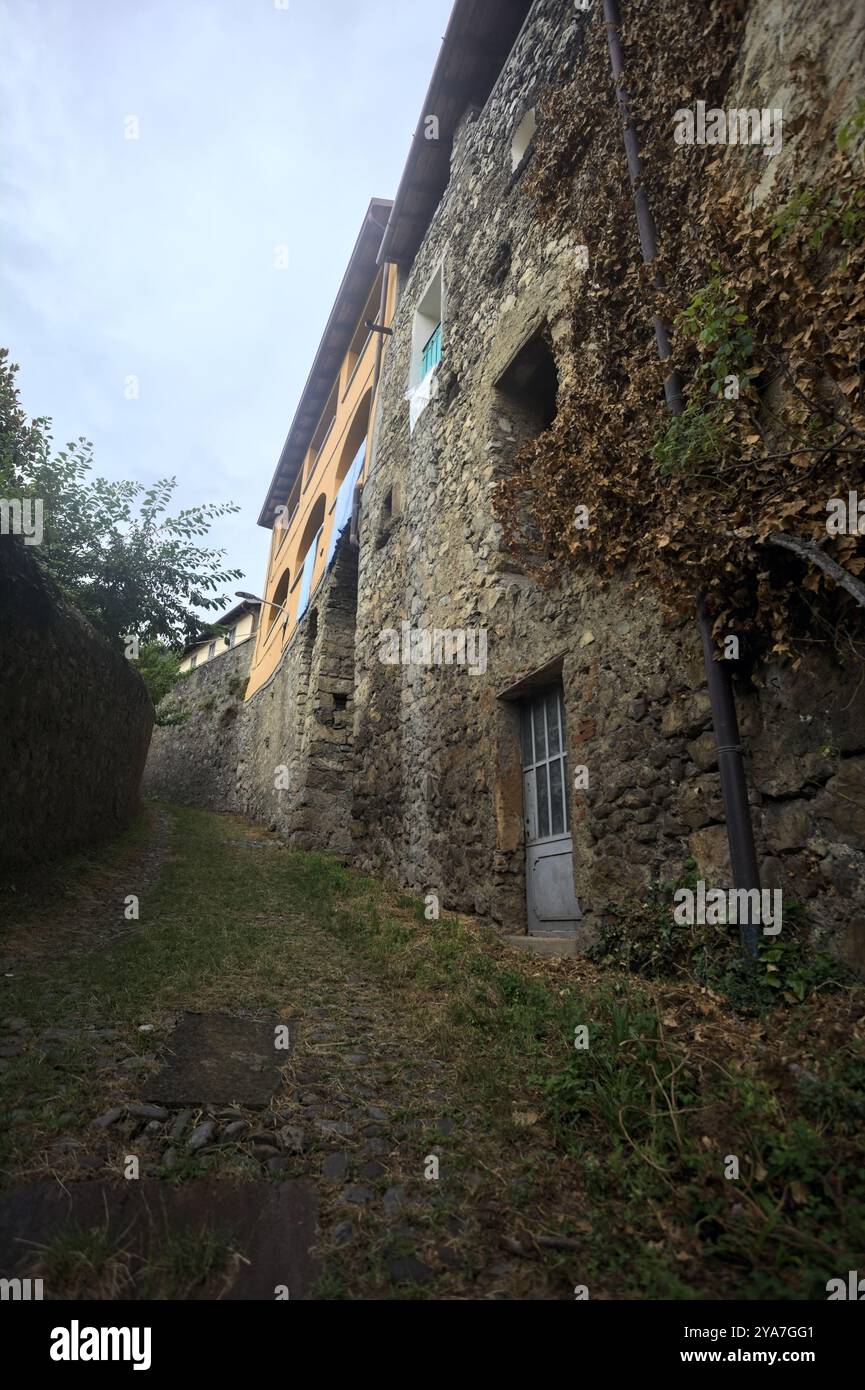 Sloppy cobbled path between a stone wall and a stone building in the ...