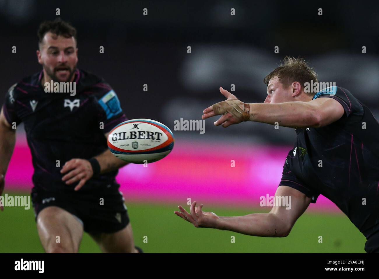 Swansea, UK. 12 October, 2024. Jac Morgan of Ospreys passes the ball to Ryan Conbeer during the Ospreys v Bulls URC Rugby Match. Credit: Gruffydd Thomas/Alamy Stock Photo