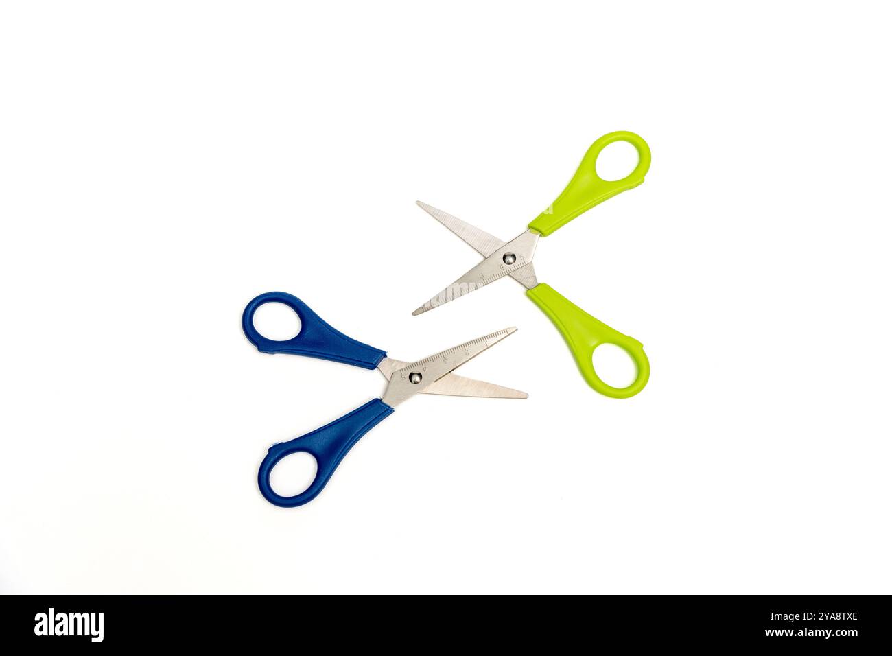 Two scissors, one blue and one green, lie on a white background. Blue ...