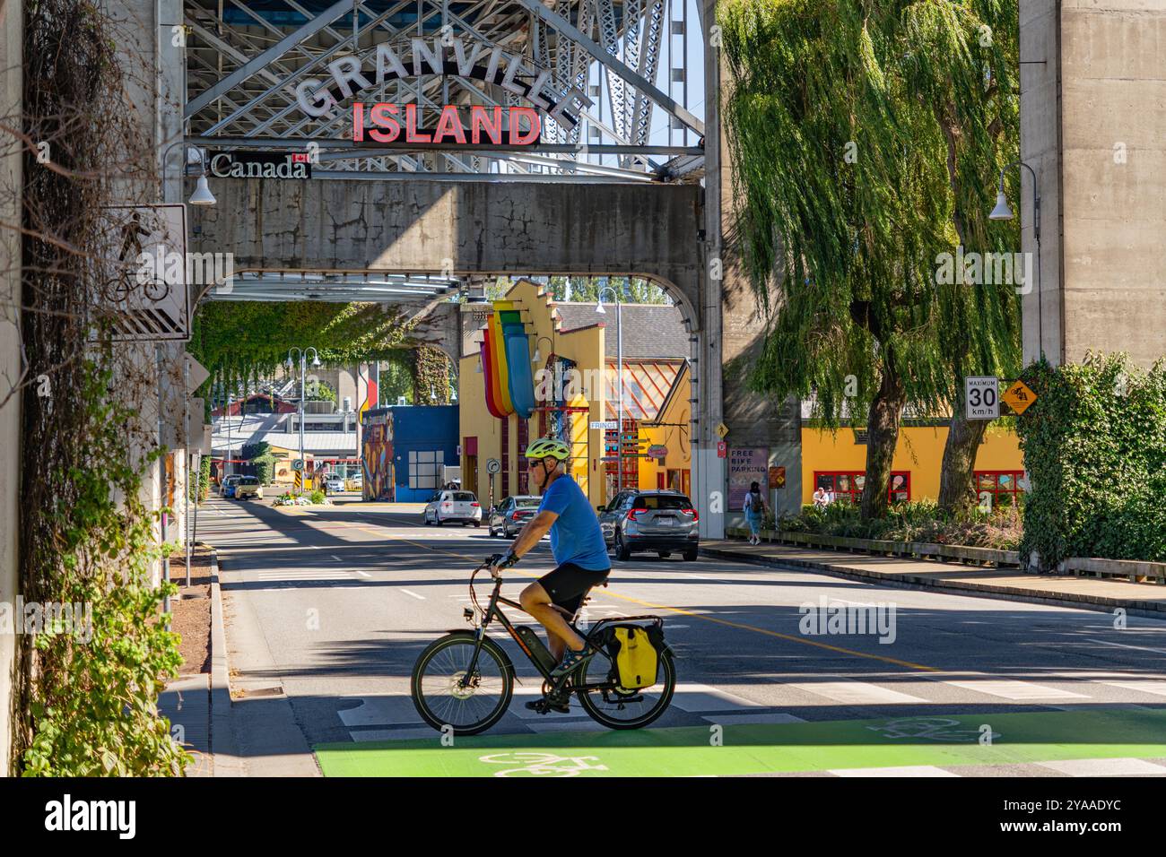 Vancouver, BC, Canada, September 4, 2024: Granville Island sign, a public market and tourist attraction with bicyclist in foreground. Stock Photo