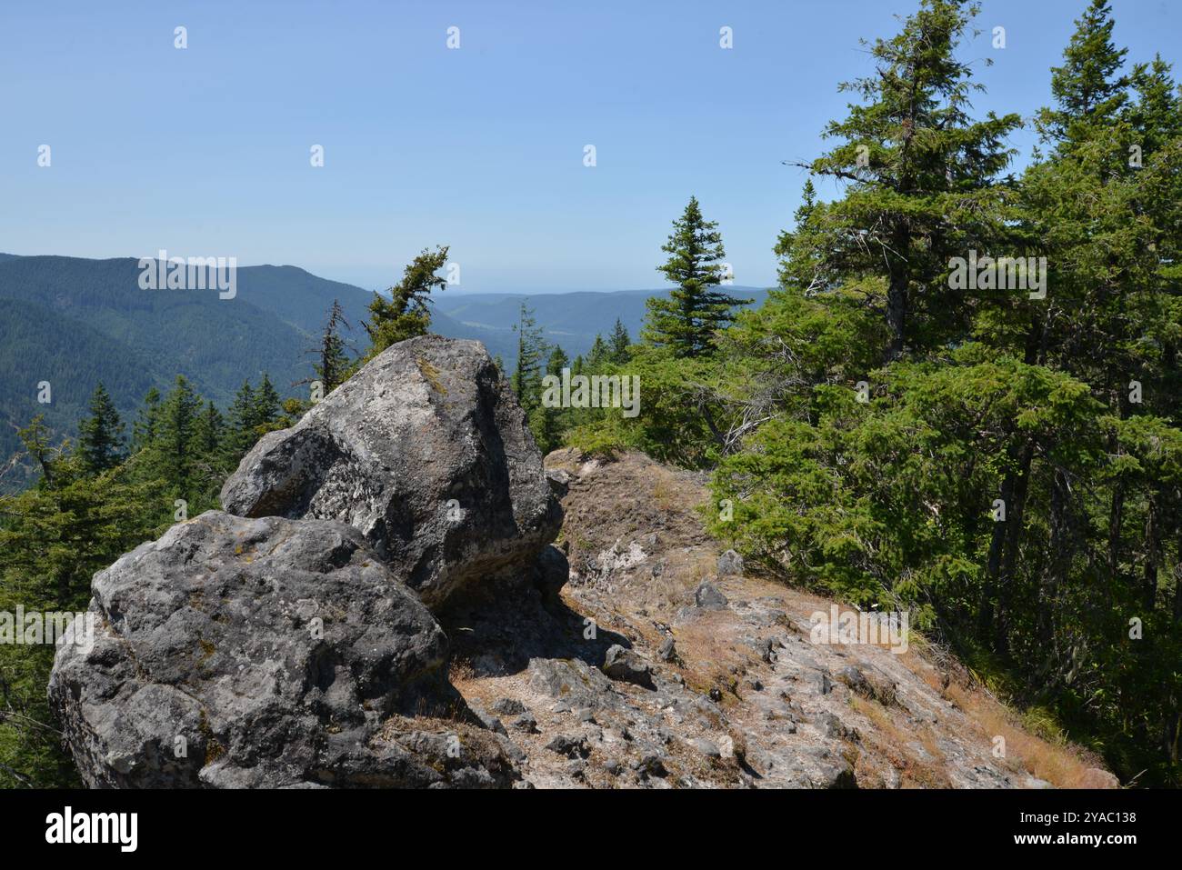Narrow Ridge Path Narrow hiking path winds along mountain ridge and around two boulders ...