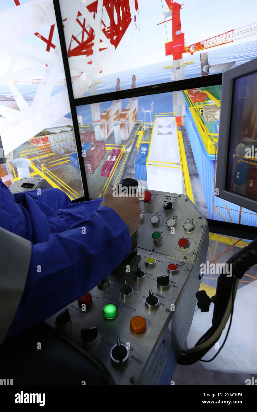 Worker in a crane simulator Stock Photo