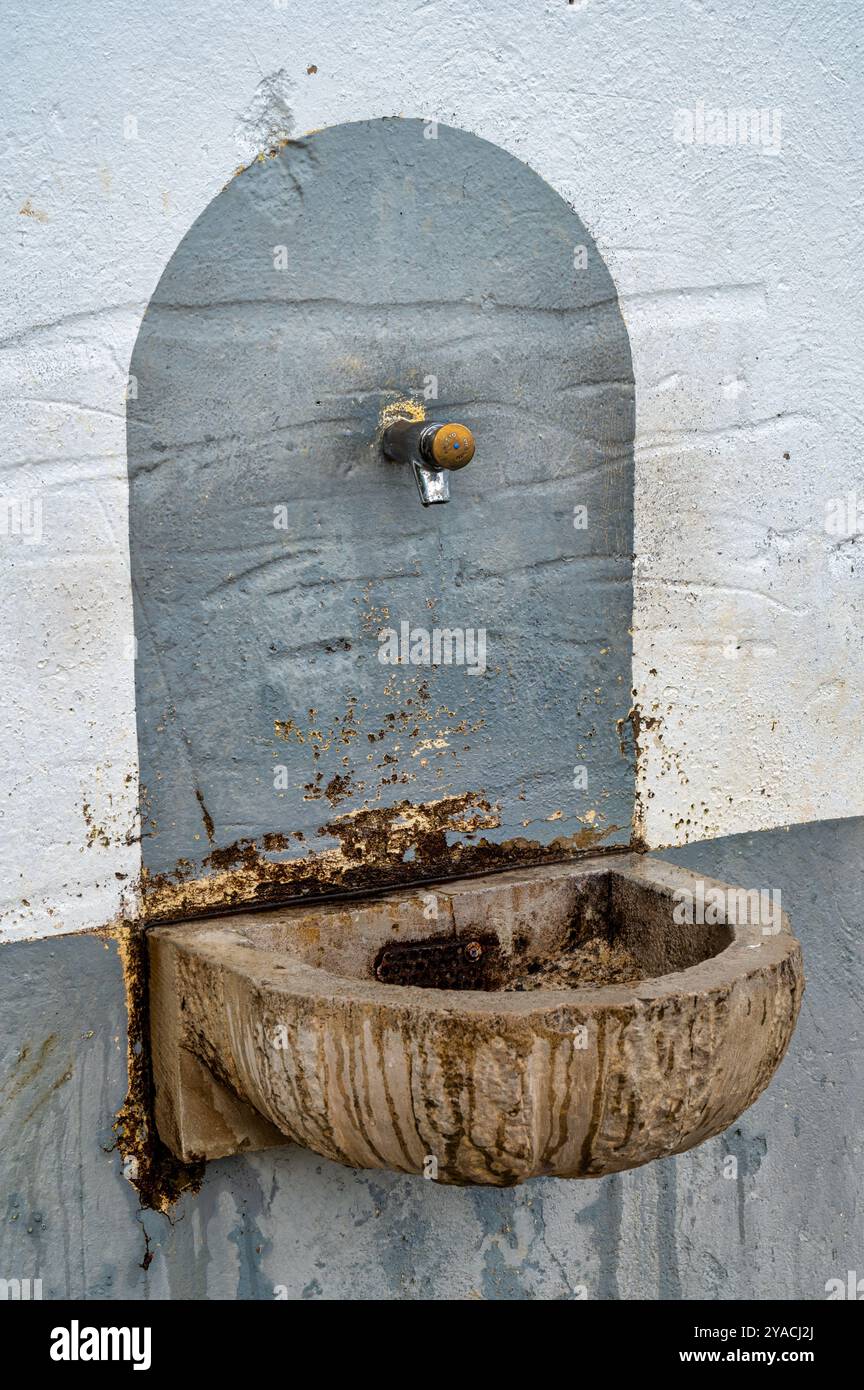 Drinking water faucet coming out of a wall in Spain Stock Photo