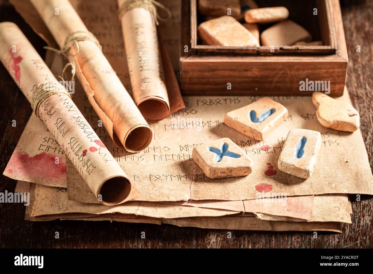 Top view of futhark rune stones amd old scrolls on wooden table as a ...