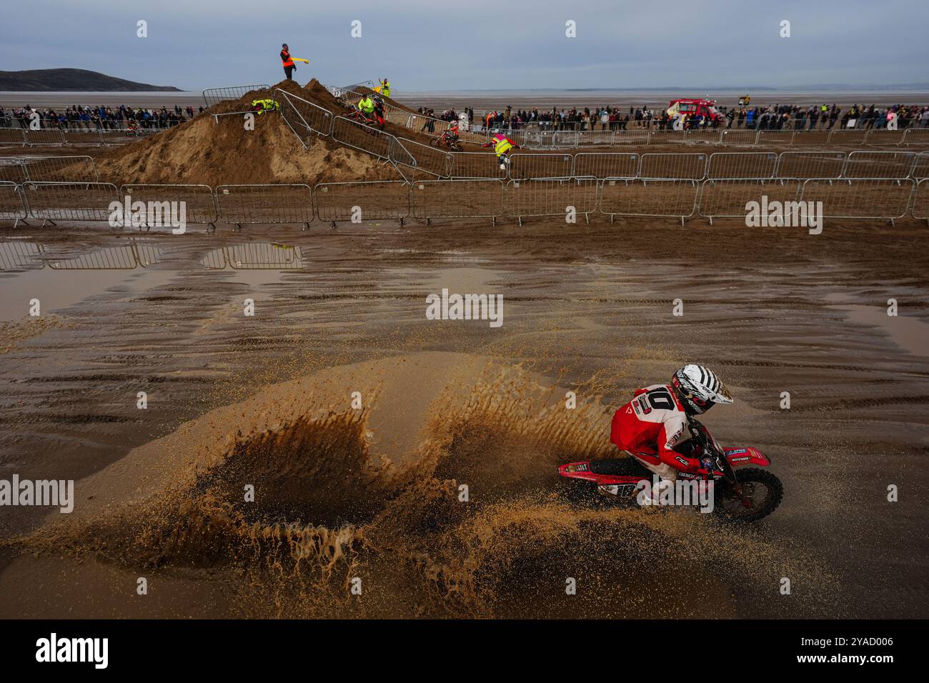 A competitor in the 65cc class splashes through a puddle during the ...