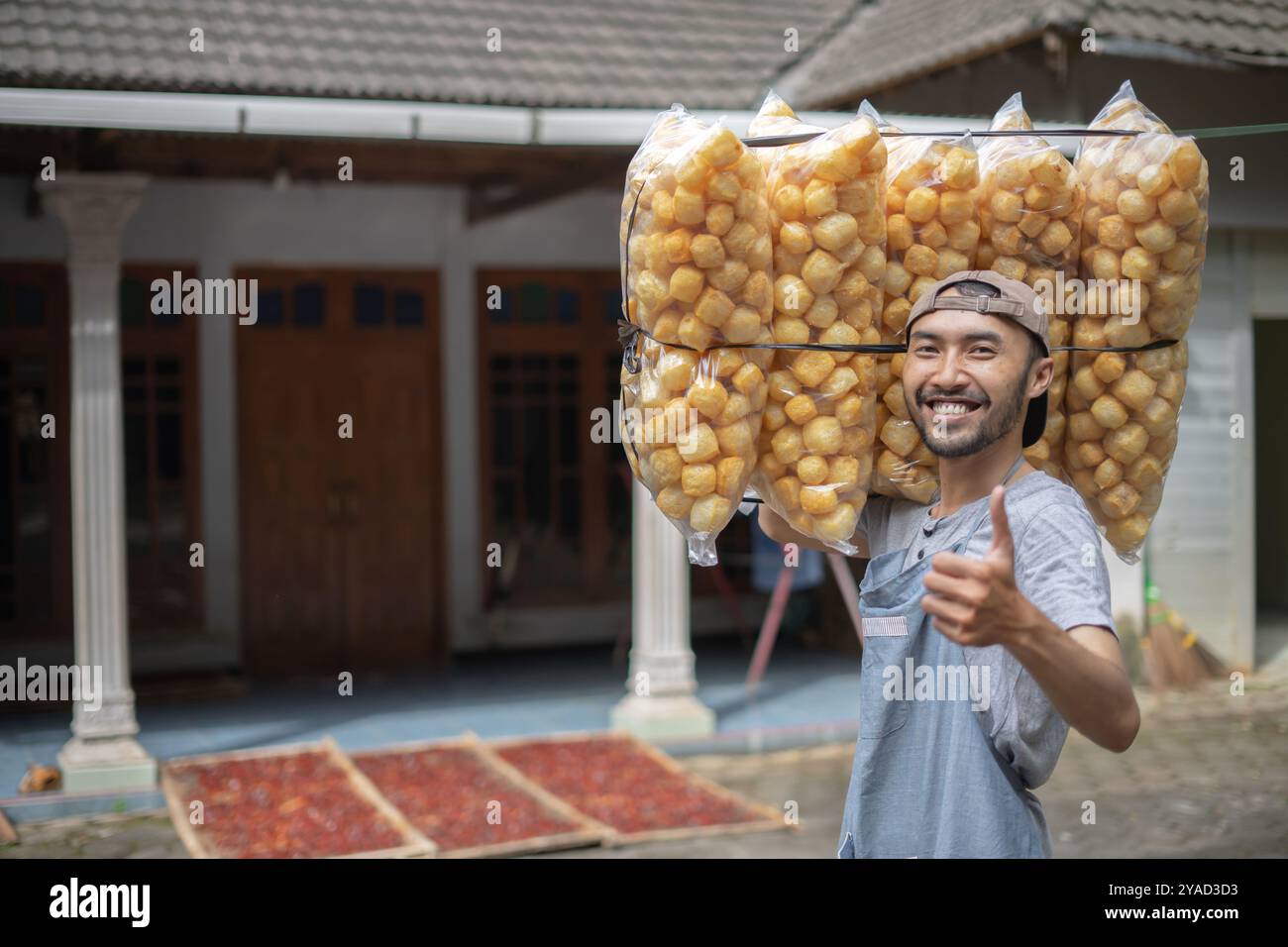 A Joyful Vendor Proudly Carrying Freshly Made Snacks on His Shoulders with Glee Stock Photo