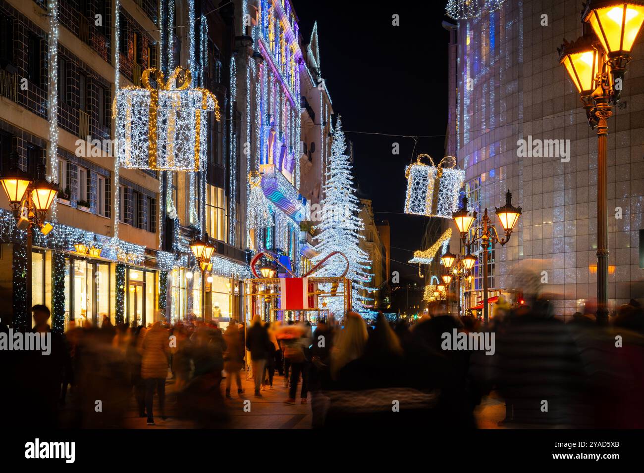 Festive Christmas lights on a busy Budapest shopping street at night Stock Photo