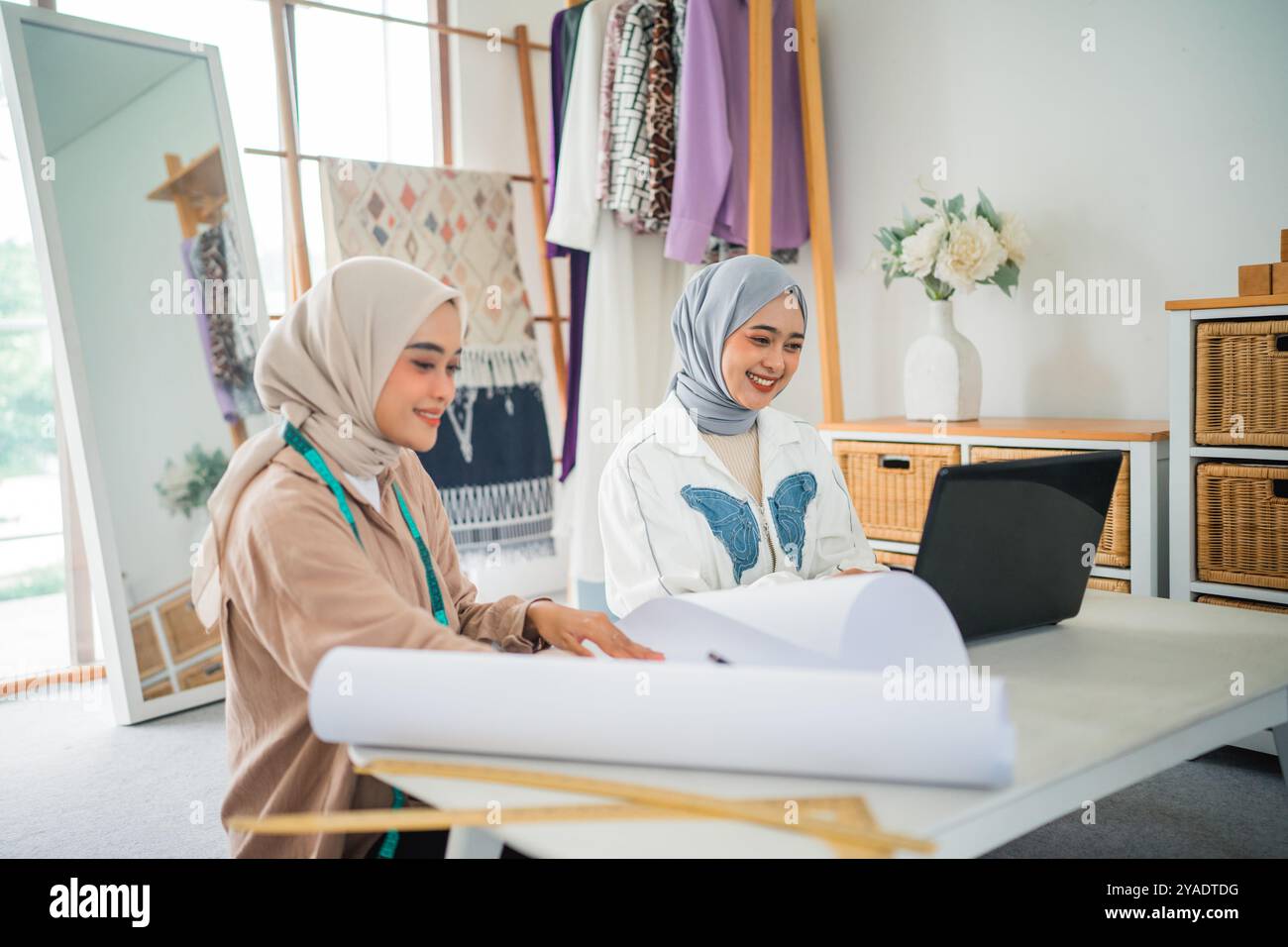 Collaborative Designers Engaged in Creative Work Within a Fashion Studio Environment Stock Photo