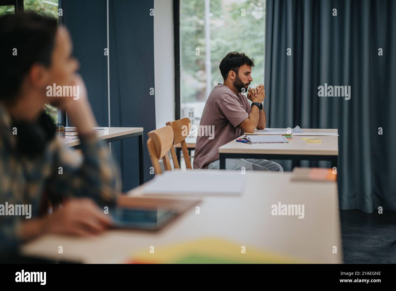 Stressed student preparing for an exam in a quiet classroom Stock Photo