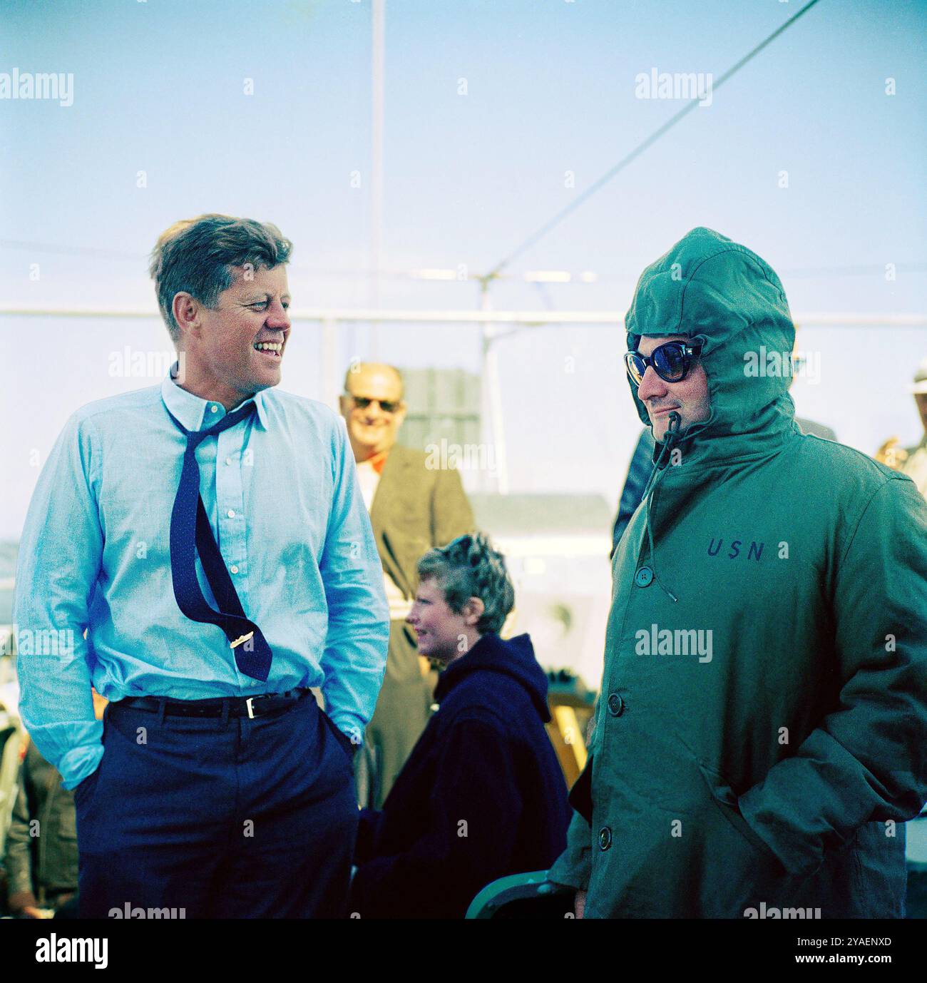 U.S. President John F. Kennedy (wearing a PT-109 pin on his tie) laughing with Press Secretary Pierre Salinger (right) during fourth race of America's Cup from aboard USS Joseph P. Kennedy, Jr., Newport, Rhode Island, USA, Cecil Stoughton, White House Photographs, September 22, 1962 Stock Photo