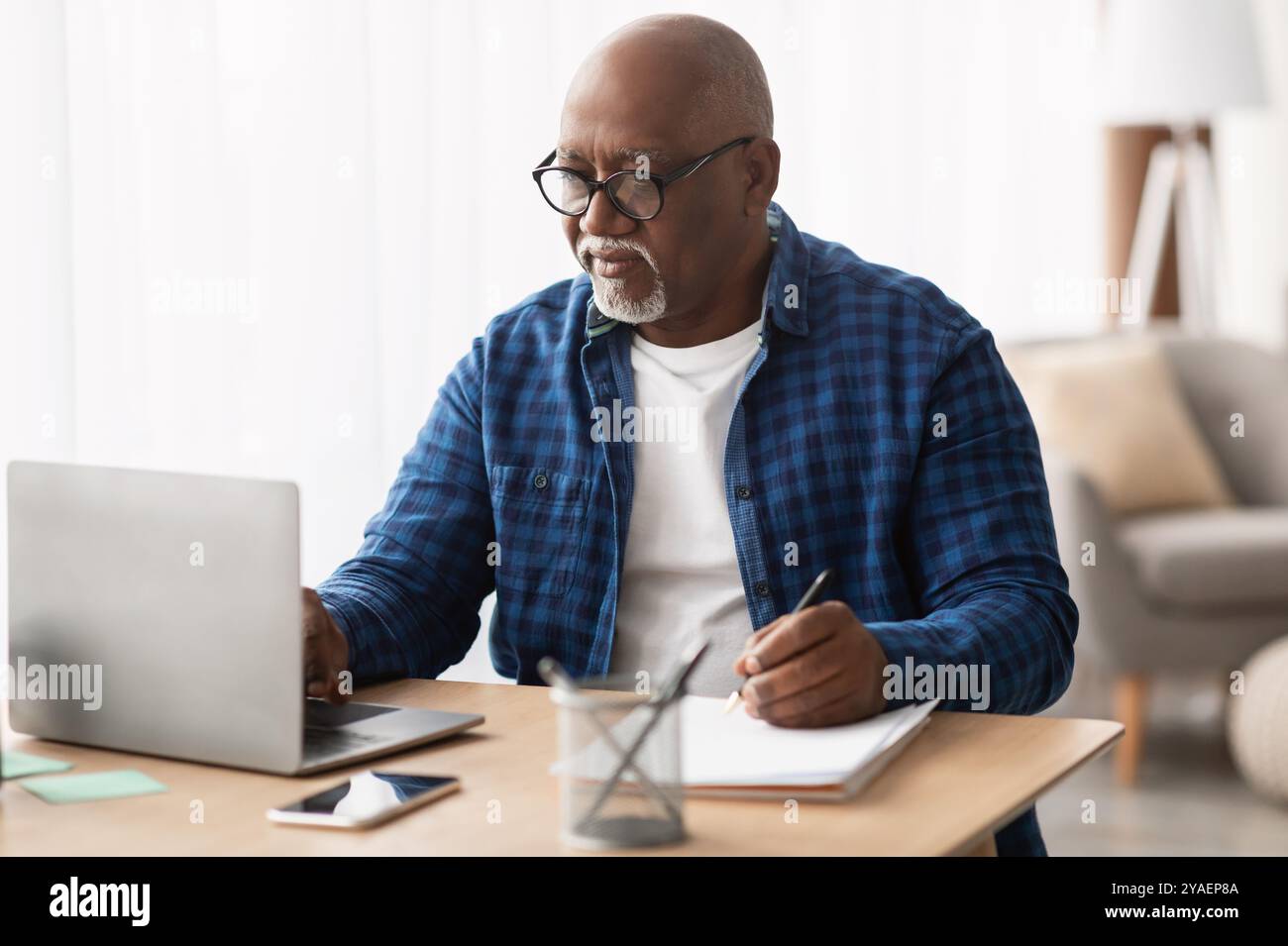 Black Man Using Laptop Taking Notes In Office, Wearing Eyeglasses Stock ...