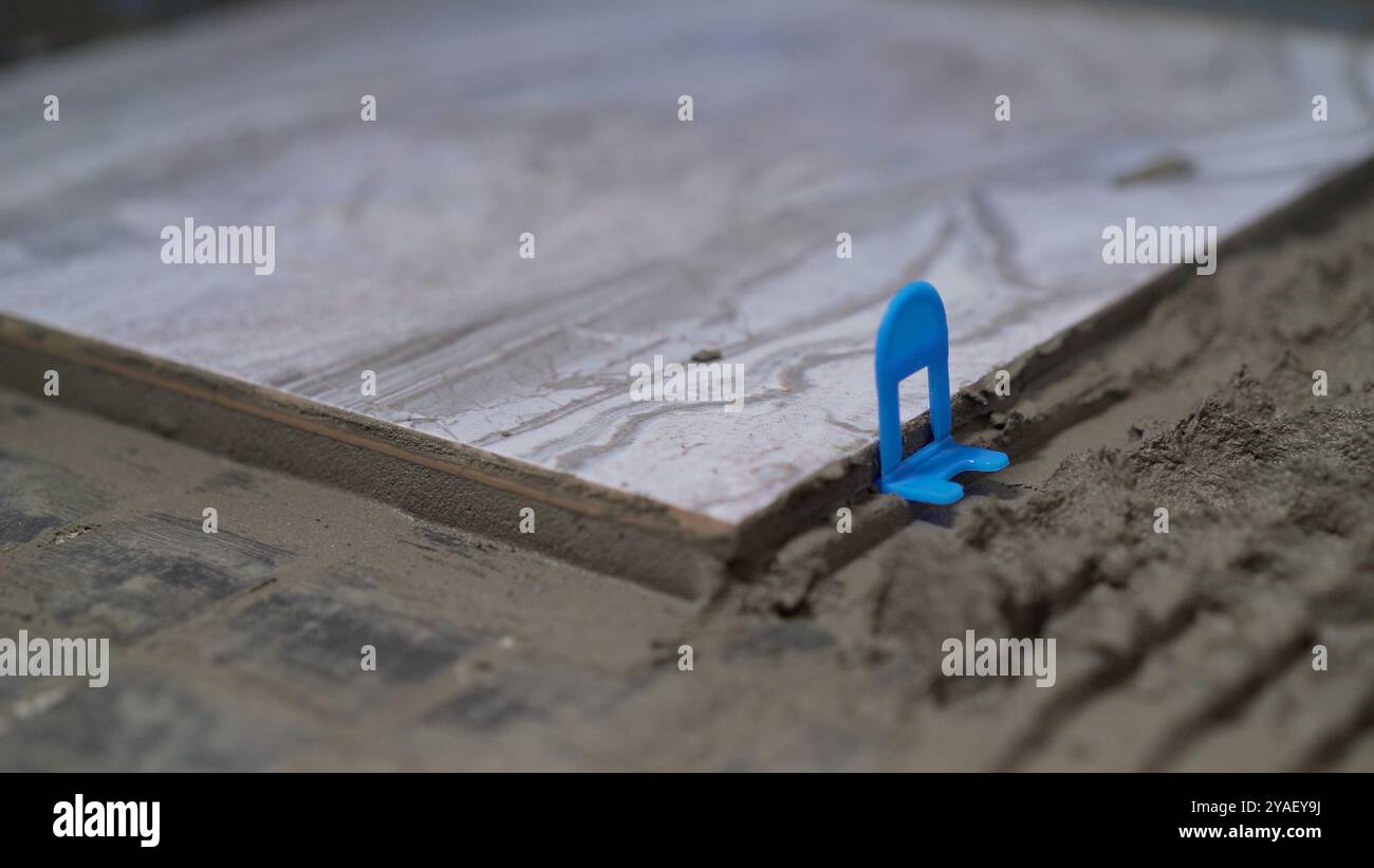 Construction Worker Laying Ceramic Tile Using Tile Leveling System
