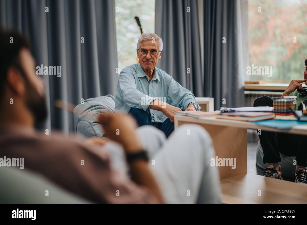 Professor engaging with students in a relaxed classroom setting Stock Photo