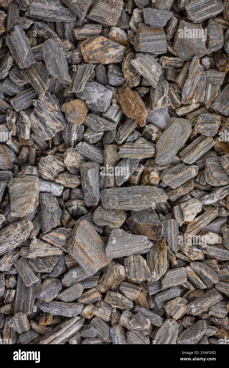 Close-up of grey and brown textured rocks forming a natural surface background. Concept of geology, earth materials, construction, and nature patterns Stock Photo