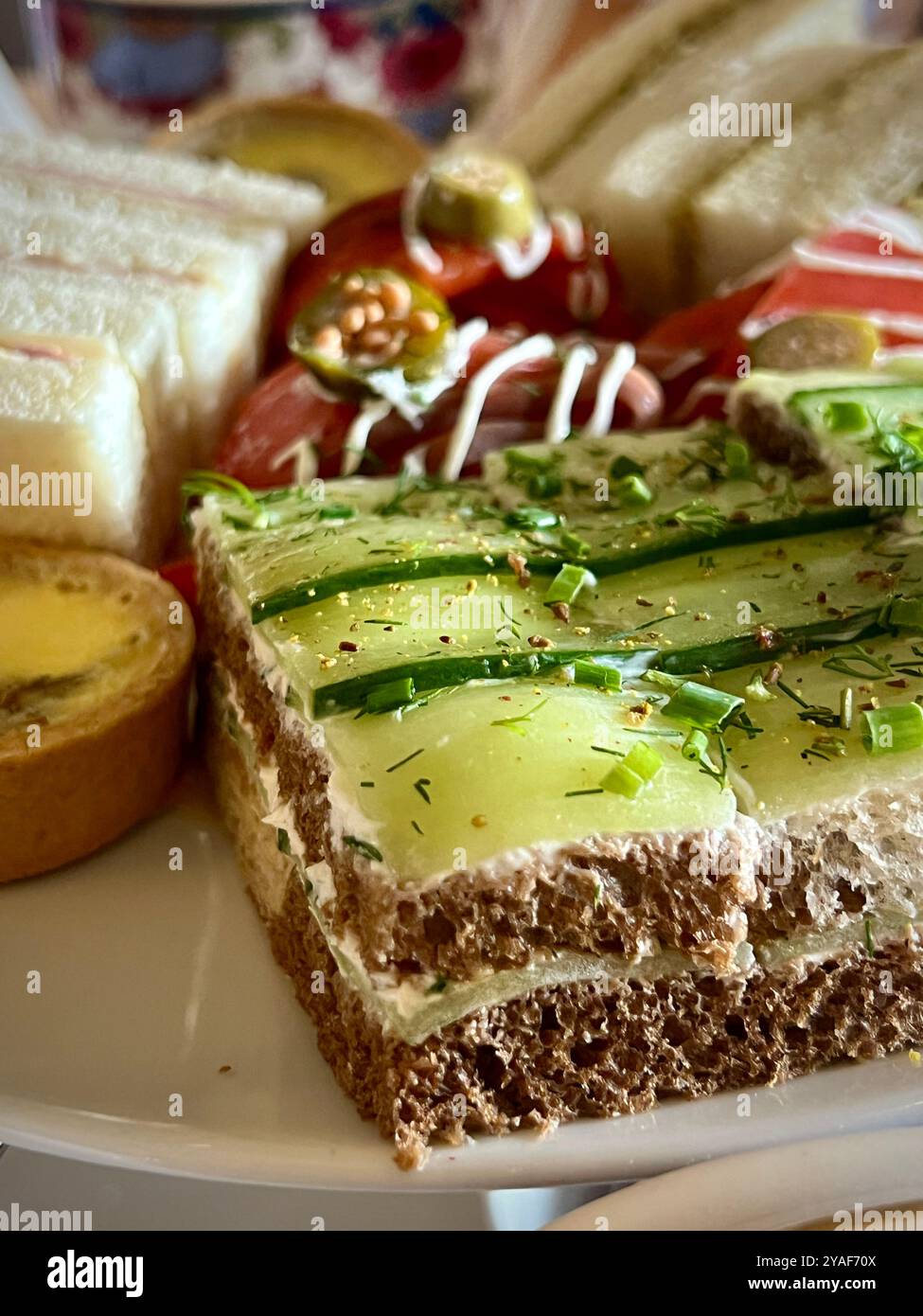 A close-up of gourmet finger sandwiches, including cucumber and smoked salmon, served during High Tea at the Empress Hotel. - Smartphone Captured Stock Image