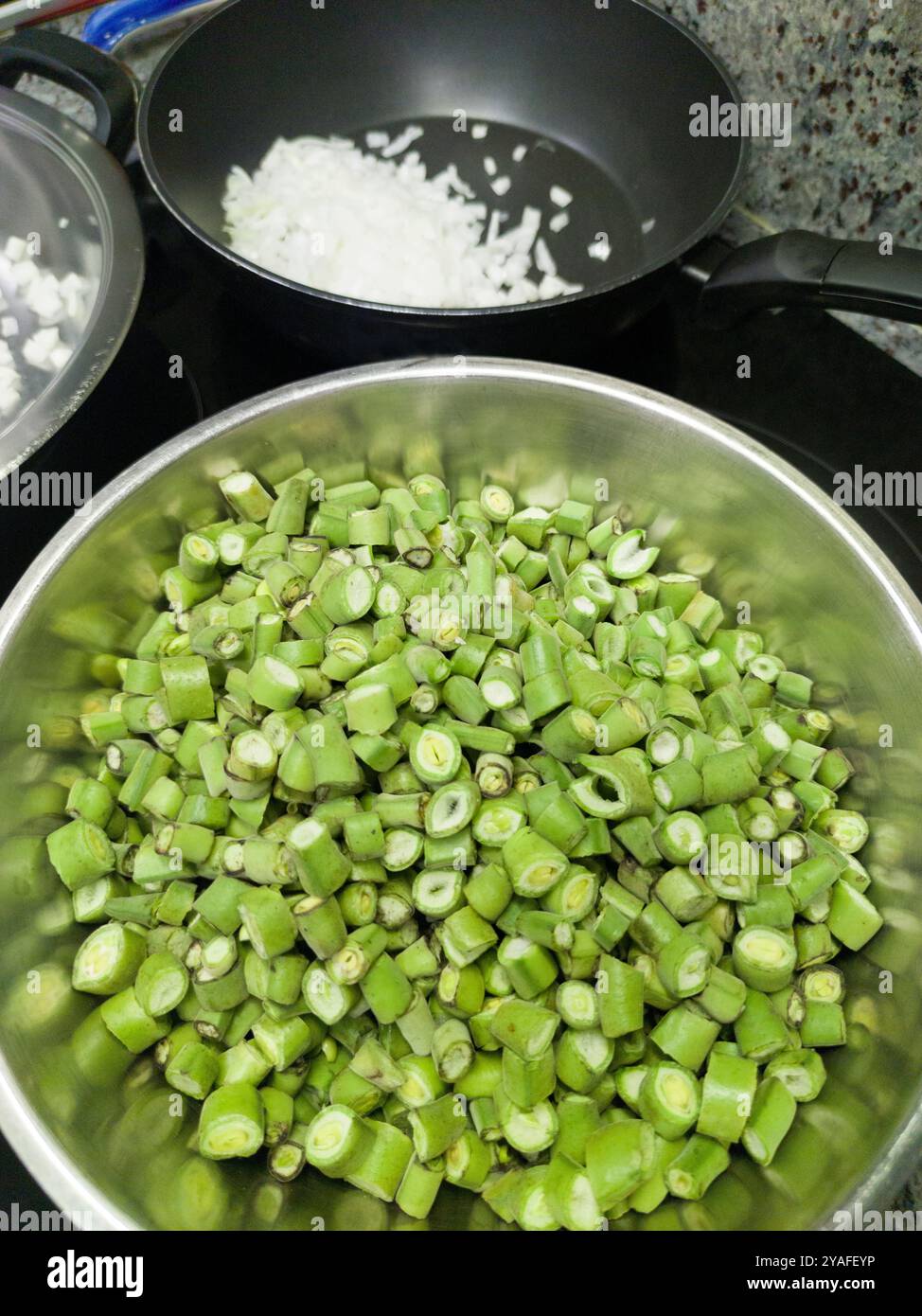 Chopped broad bean pods ready to cook. Arranged in an aluminum bowl Stock Photo