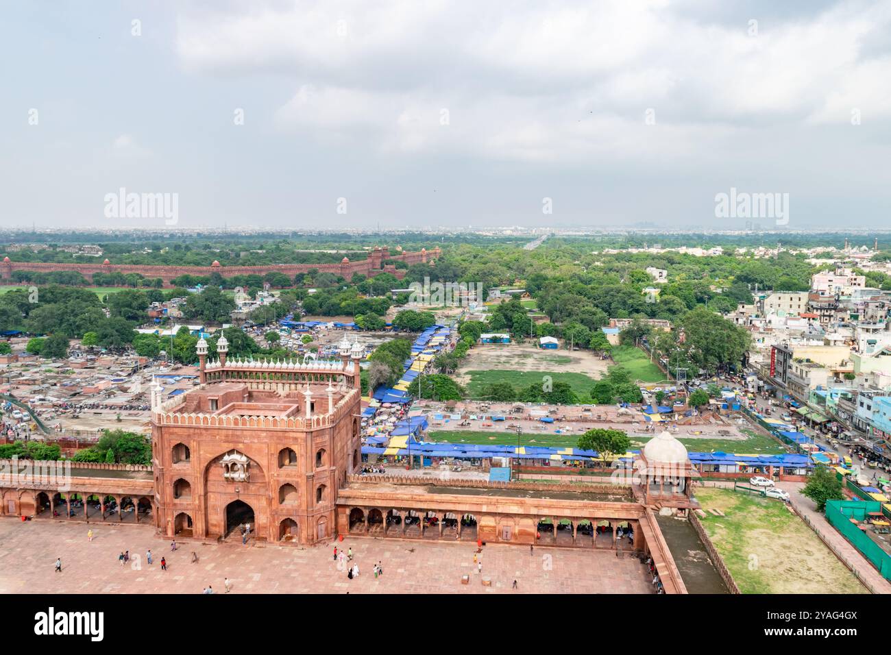 Tourists exploring the jama masjid mosque in delhi, india with a view of the red fort in the distance Stock Photo