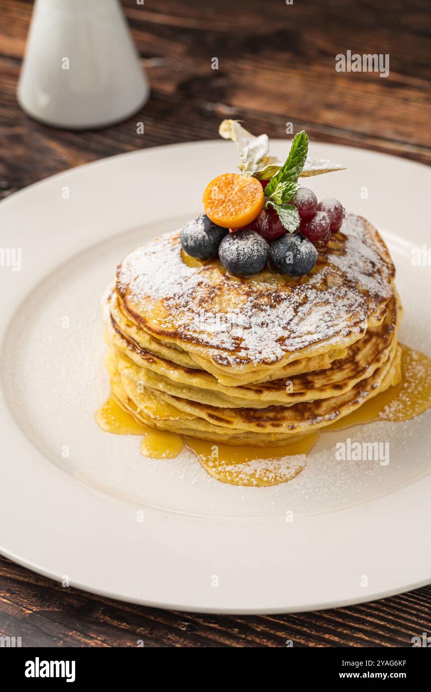 Pancakes with fruit and maple syrup on a white plate Stock Photo