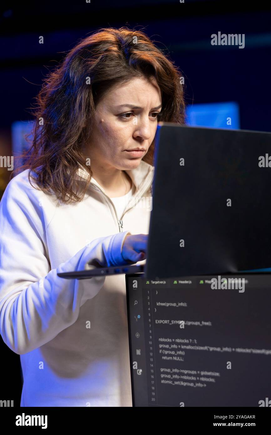 Programmer typing on laptop keyboard, implementing and maintaining security measures. Expert writing, testing and debugging Java code for software applications on notebook device Stock Photo