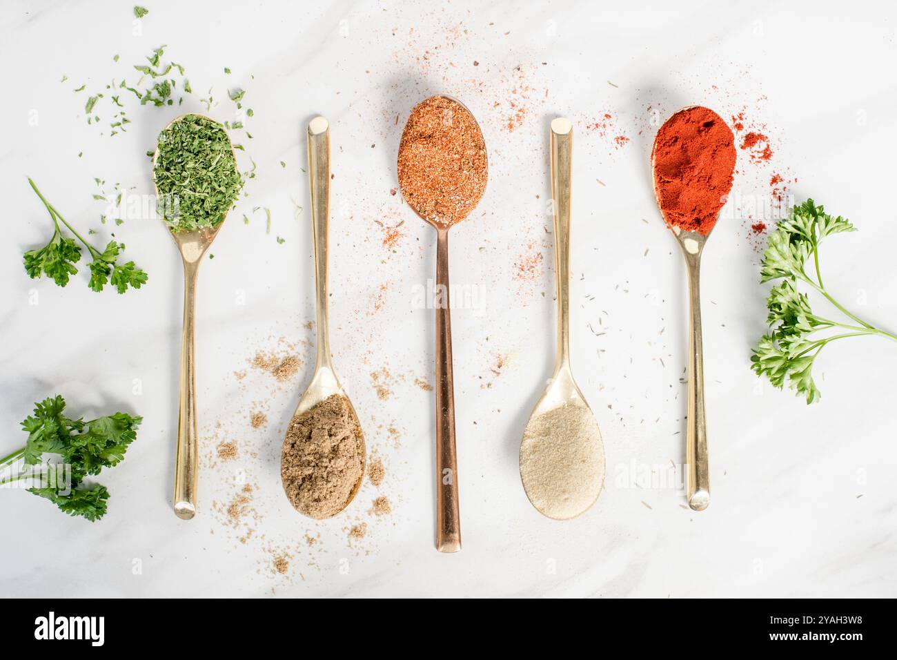 Five different spices in spoons on a table Stock Photo