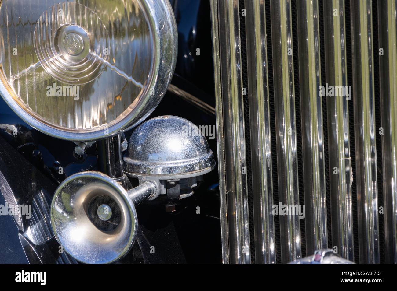 Gleaming chrome parts shine on the front of a vintage rolls royce, showing off its classic design Stock Photo