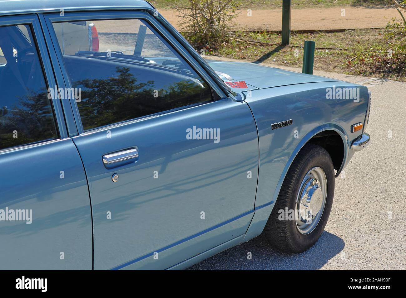 Vintage toyota corolla is parked on the side of the road, gleaming in the afternoon sun Stock Photo