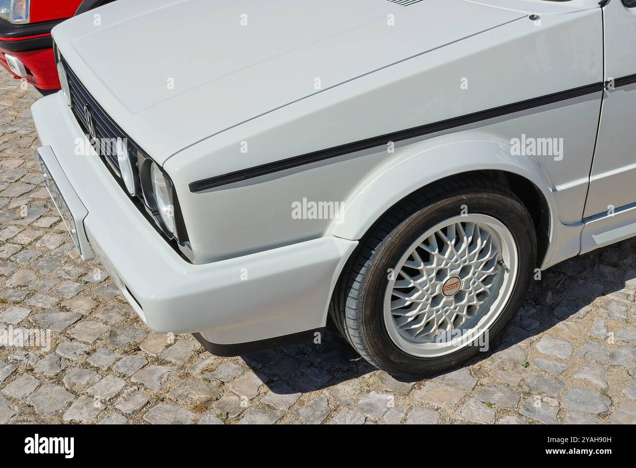 Front end of a white volkswagen golf gti parked on cobblestones Stock Photo