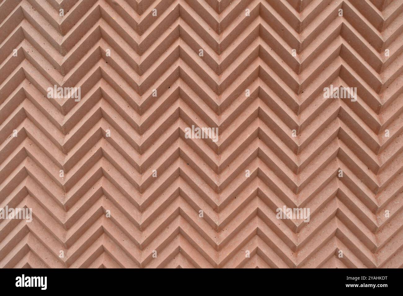 Pattern of textured zigzag lines on a terracotta wall. Backgrounds and textures. Stock Photo