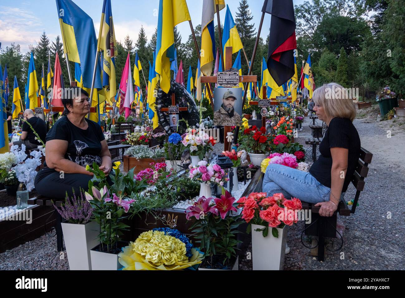 10.09.2024, Ukraine, Lviv, Lviv - Mutter und Witwe am Grab eines Soldaten auf dem Marsfeld, Ehrenfriedhof der gefallenen Lwiwer Soldaten im Ukrainekri Stock Photo