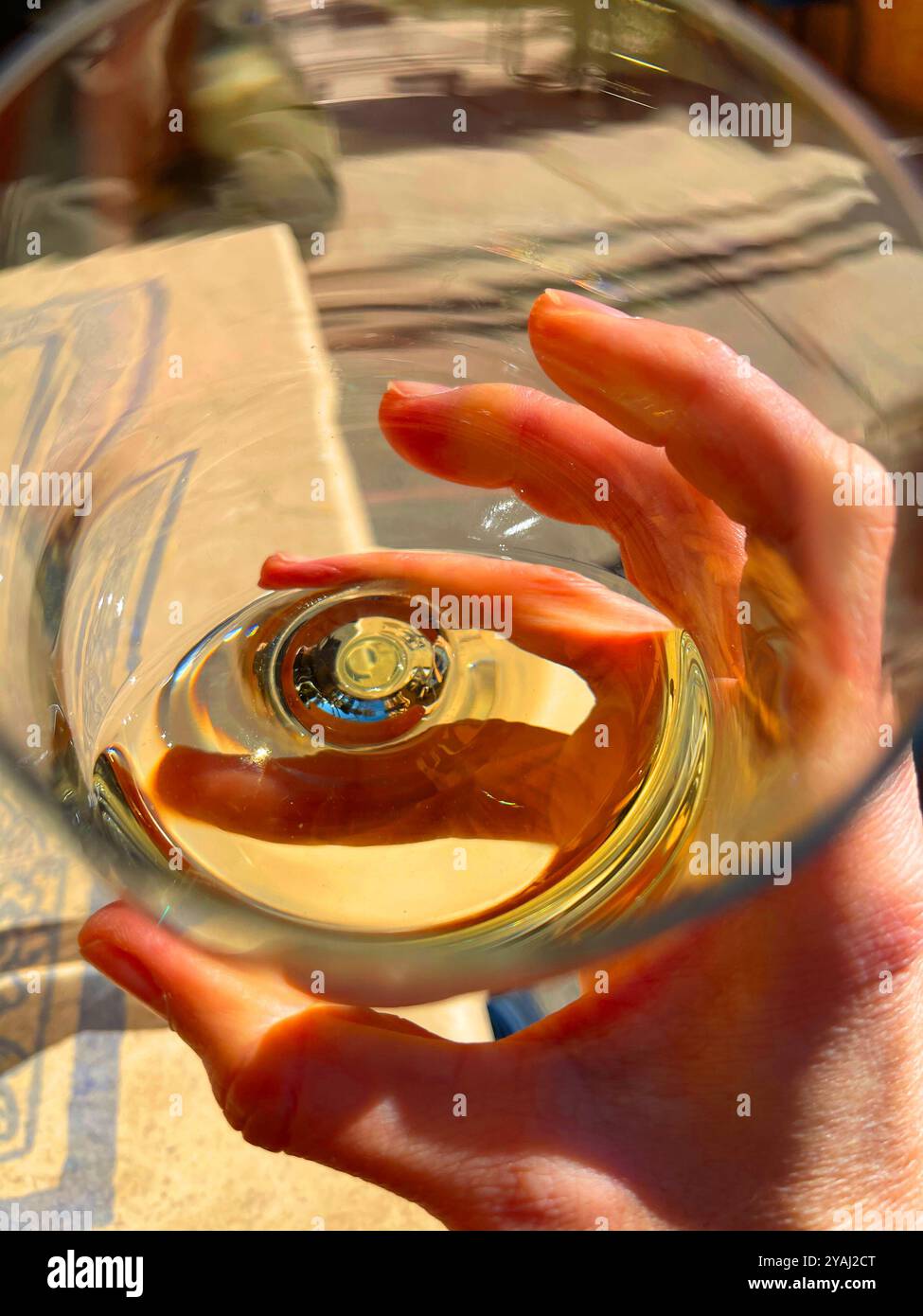 Hand holding a glass of white wine. Subjective camera. - Smartphone Captured Stock Image