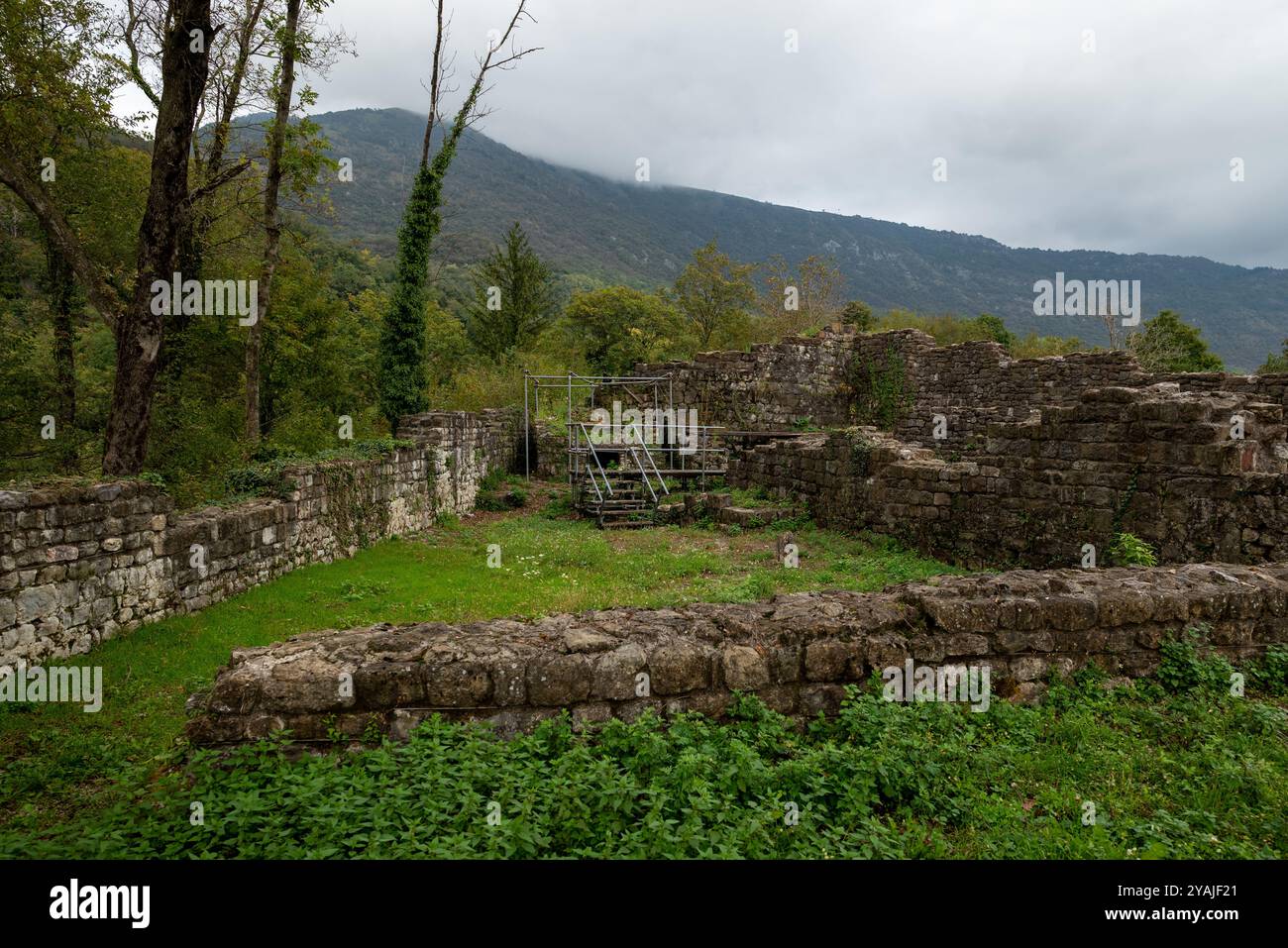 Ruins of the ancient castle of Meduno in the Friuli Venezia Giulia region (Italy). It is under restoration. There is a long wooden boardwalk and a met Stock Photo