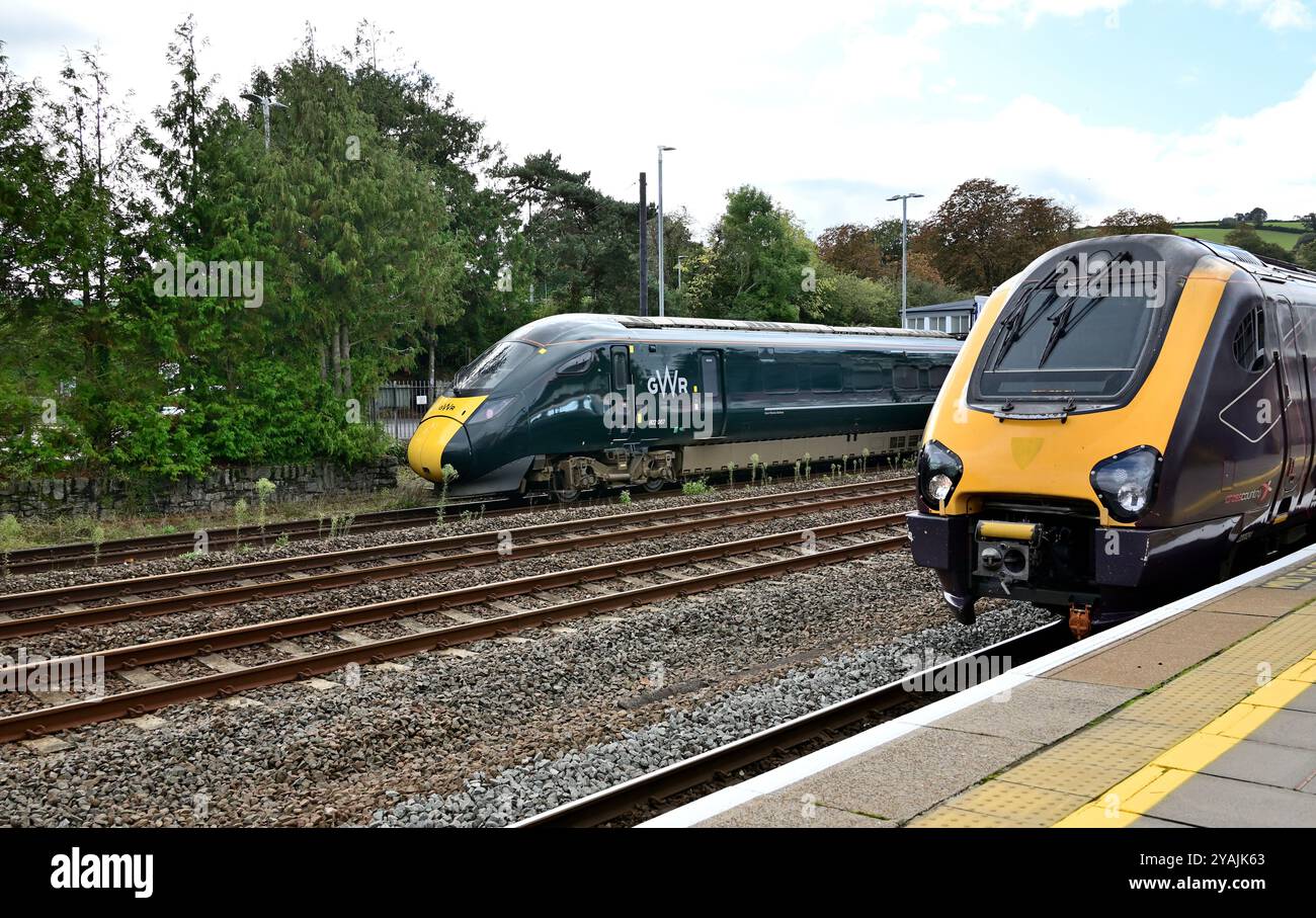 CrossCountry train 1S49 the 11.27 Plymouth to Edinburgh waits to leave Totnes headed by power car No 220024, as an Intercity Express Train arrives. Stock Photo