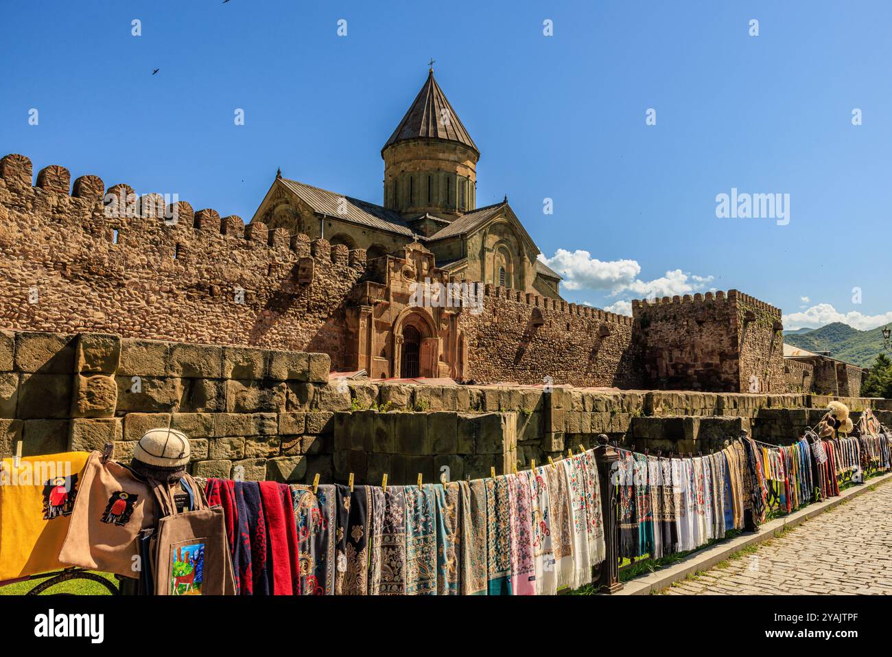 market traders hang colourful textiles on railings in front of the ...