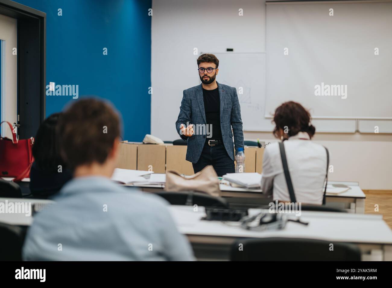 Professor assisting students during interactive classroom session Stock Photo