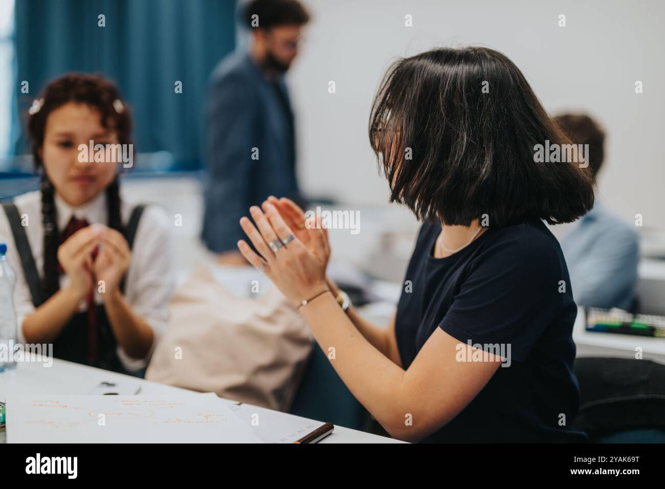 Students collaborating on tasks with guidance from a professor Stock Photo