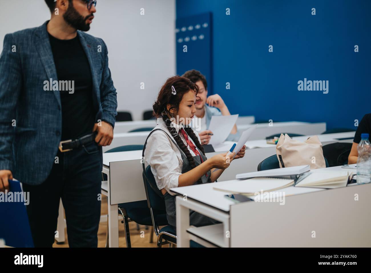 Professor assists students during a classroom task session Stock Photo