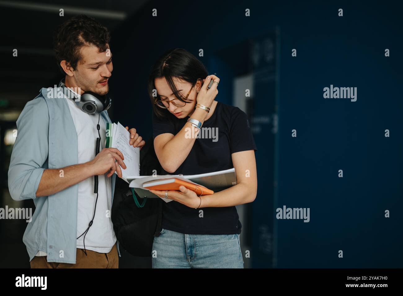 Two students discussing coursework in a hallway at university Stock Photo