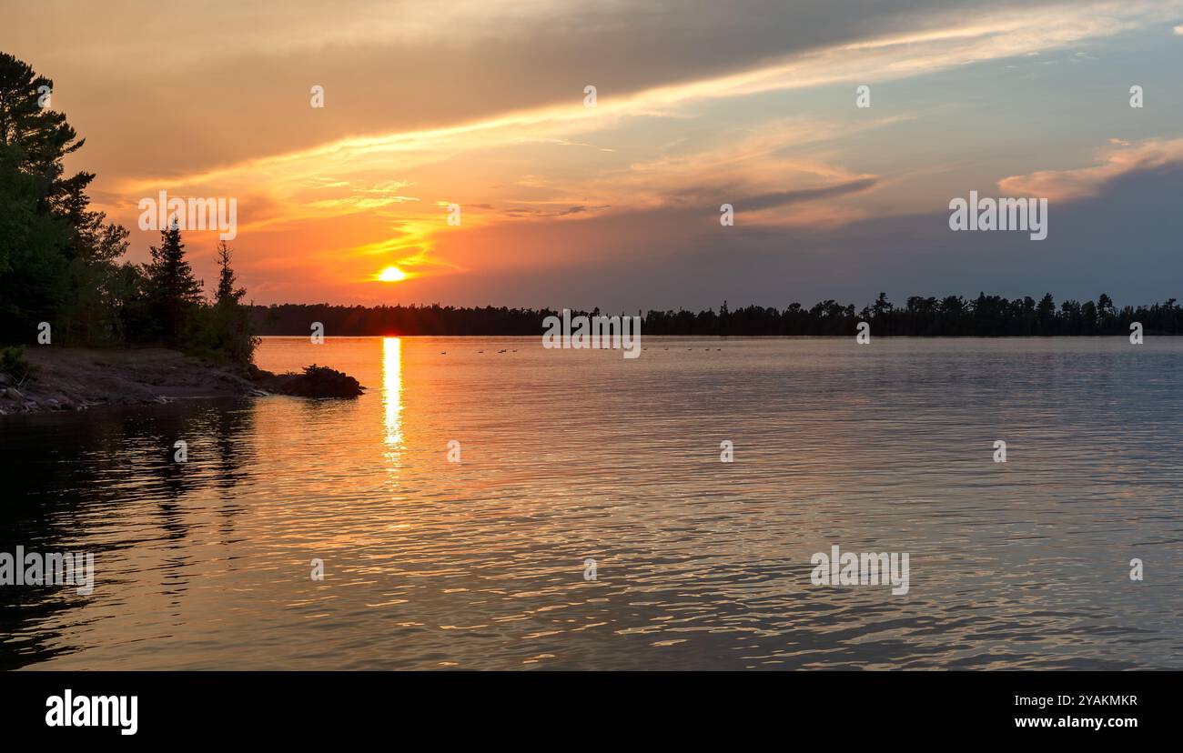 Sunset over water in the Northwoods.  Lake Superior in Michigan's Upper Peninsula.  Copy space if needed.  Concepts could include nature, travel, tour Stock Photo