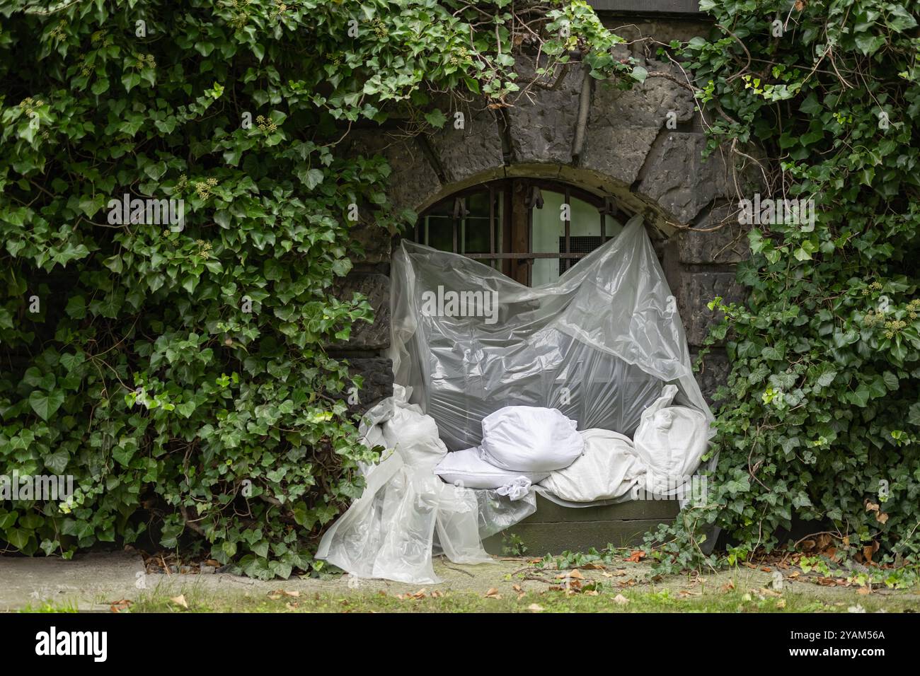 Protective plastic covers and sandbags guarding a historic building window against flood damage Stock Photo