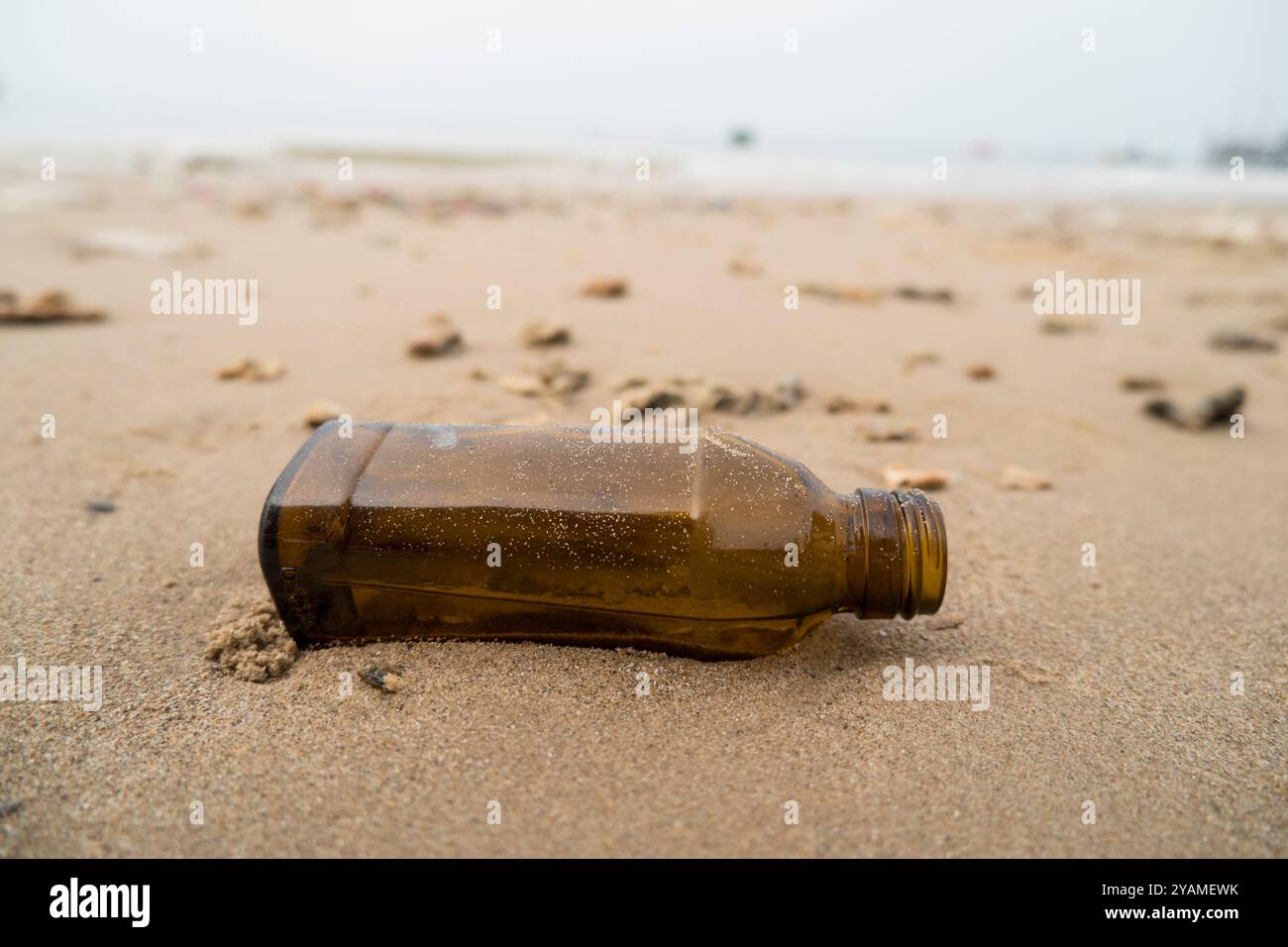 Empty glass bottles washed up on the beach Stock Photo