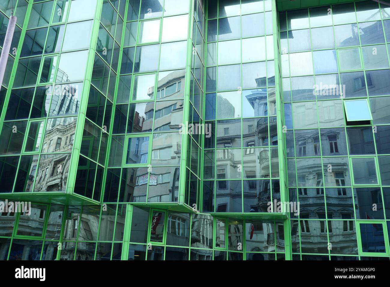 A modern office building facade with large glass windows that reflect ...