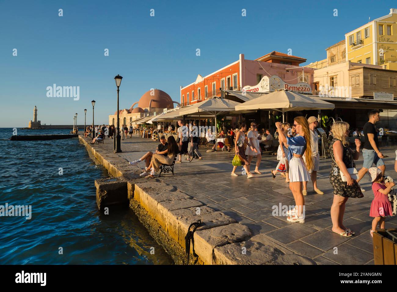 Chania Crete, view at sunset of people walking in the scenic Venetian harbour area in the historic old town quarter of Chania (Hania), Crete, Greece Stock Photo