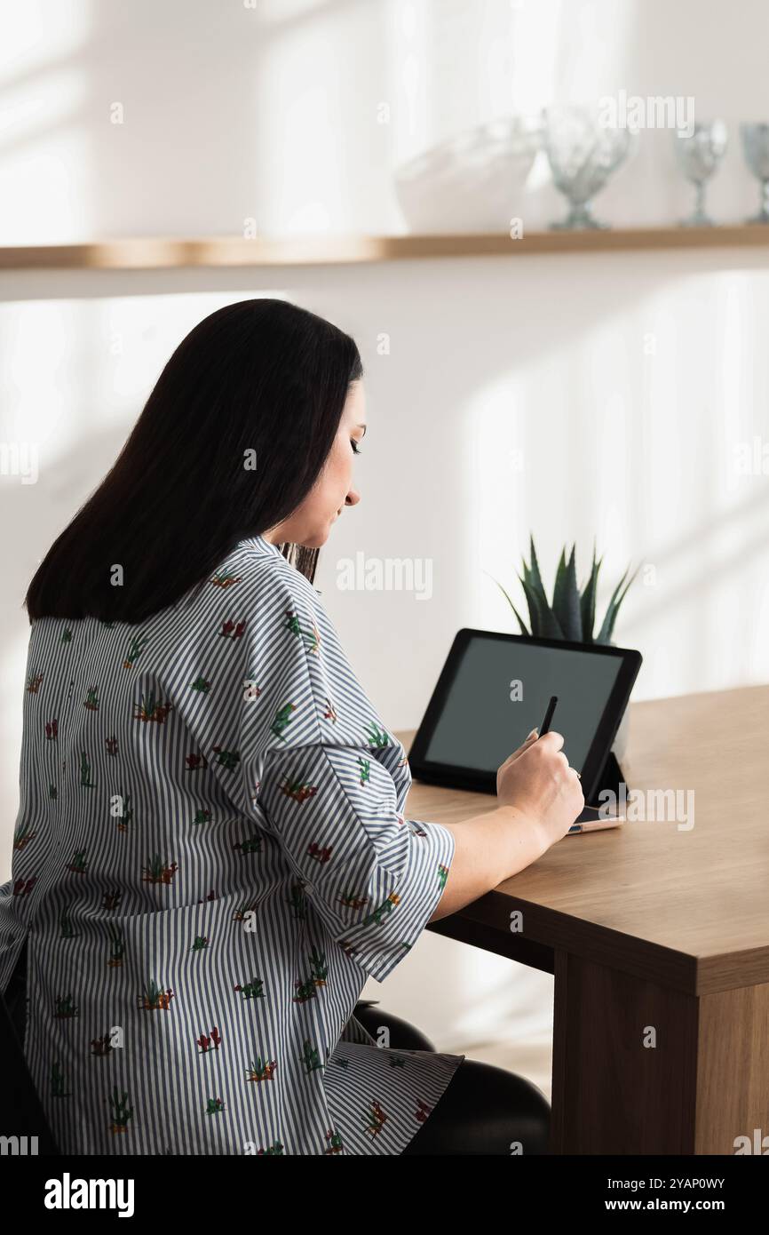 Woman Using Tablet for Digital Work at Modern Desk Stock Photo