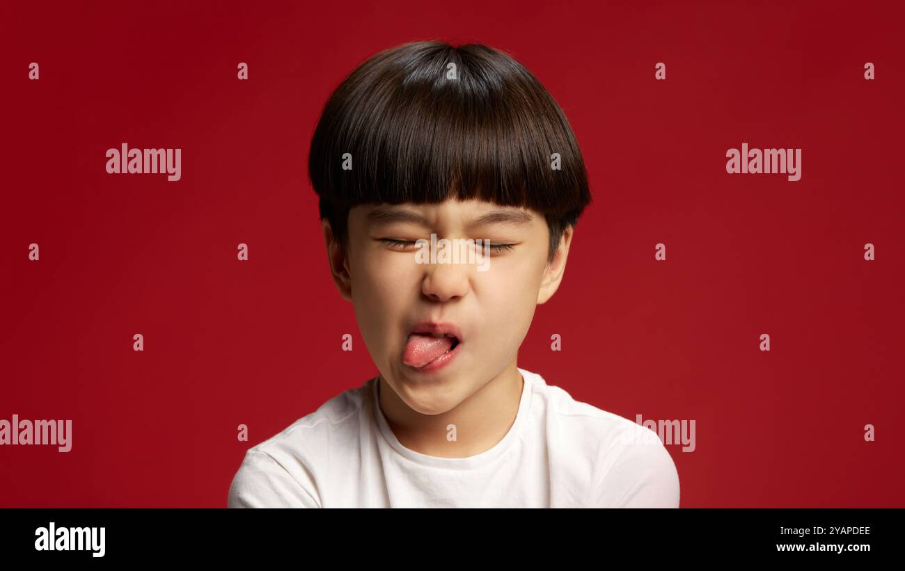Child sticks tongue out in playful defiance, capturing classic youthful ...