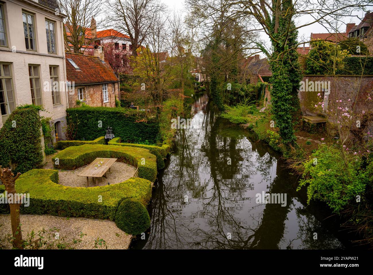 Tree lined Speelmanseri Canal and lovely secret gardens  in Bruges, Belgium. Stock Photo