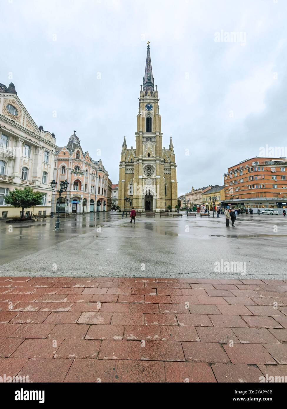 Rainy Day in Novi Sad: People at the Town Square and the Landmark- Name of Mary Church October 2024 Serbia Stock Photo