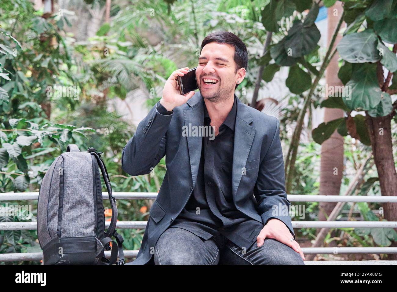 Laughing Man Talking On The Smart Phone Laughing He Is Sitting With A laughing-man-talking-on-the-smart-phone-laughing-he-is-sitting-with-a