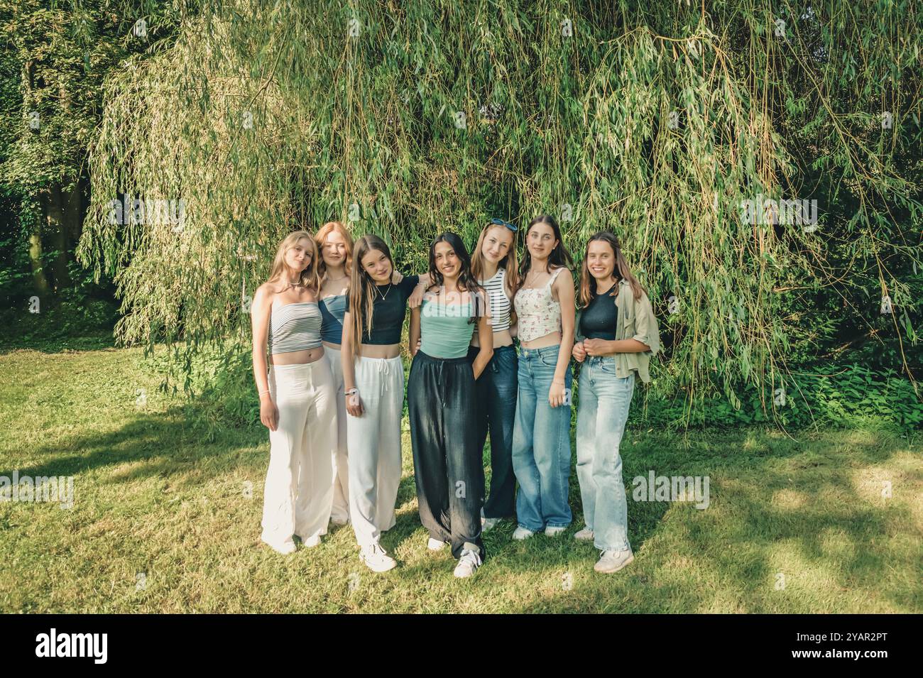 Seven caucasian teenage girls in the nature on a sunny summer afternoon ...